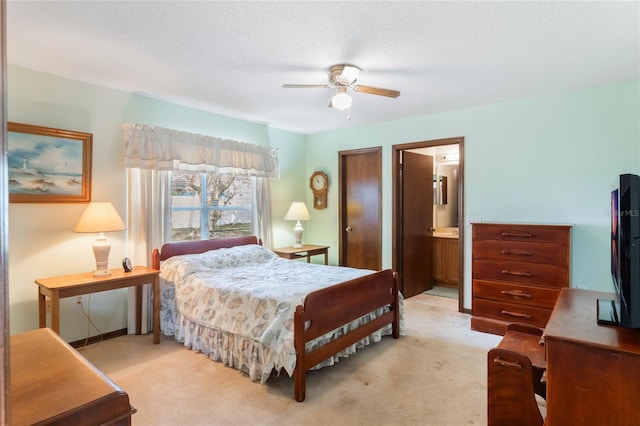 carpeted bedroom with ceiling fan, ensuite bath, and a textured ceiling