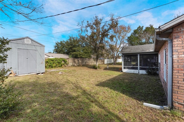 view of yard featuring a sunroom and a storage unit