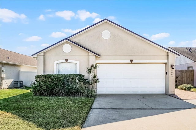 view of front of home featuring a garage, a front yard, and central AC unit