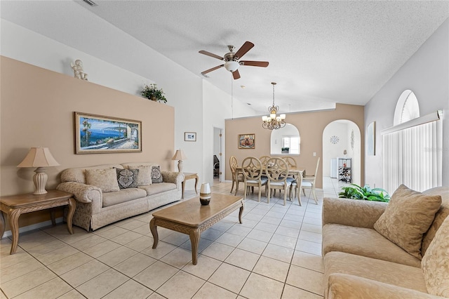 living room with ceiling fan with notable chandelier, lofted ceiling, light tile patterned floors, and a textured ceiling