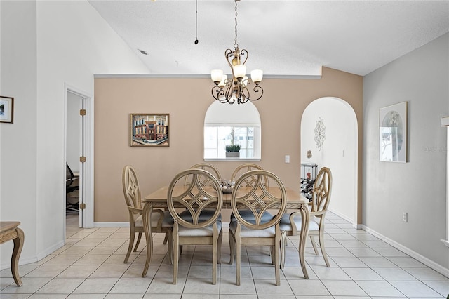 tiled dining area with lofted ceiling and a chandelier