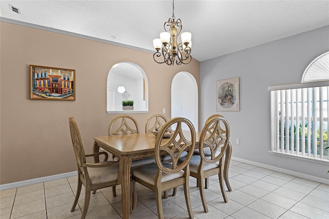 tiled dining room with plenty of natural light, a chandelier, and a textured ceiling