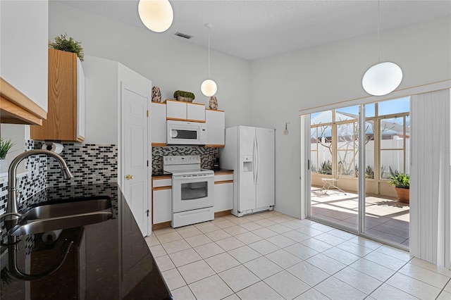 kitchen with white cabinetry, white appliances, sink, and hanging light fixtures