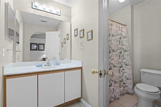 bathroom featuring tile patterned flooring, vanity, a textured ceiling, and toilet