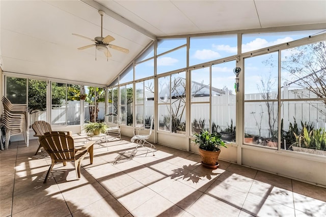 unfurnished sunroom with ceiling fan, plenty of natural light, and lofted ceiling with beams