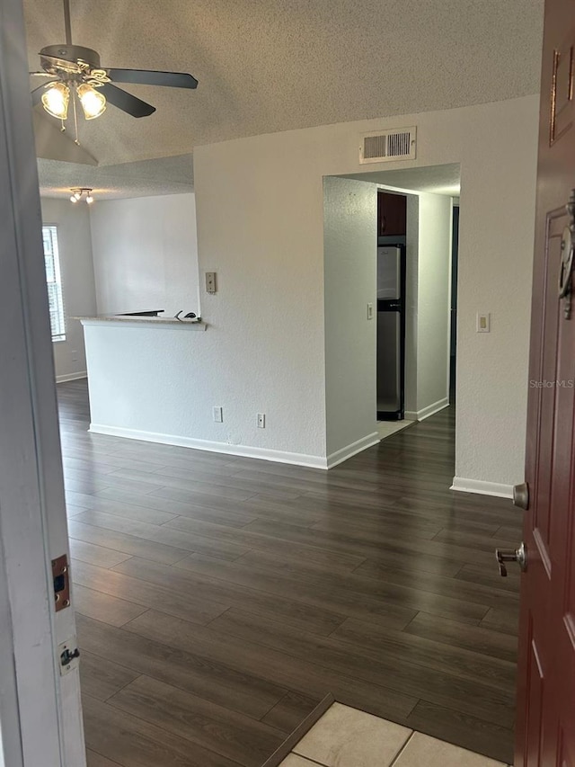 unfurnished room featuring ceiling fan, dark hardwood / wood-style floors, and a textured ceiling