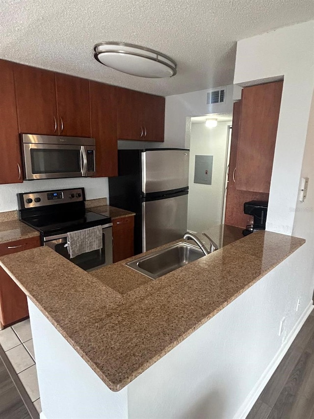 kitchen with stainless steel appliances, sink, and kitchen peninsula