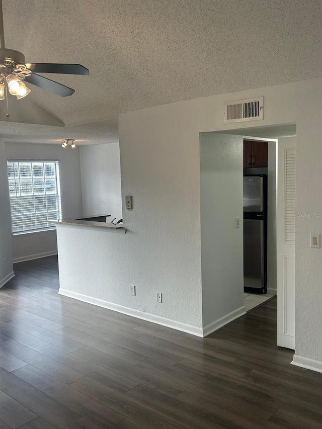 unfurnished room with ceiling fan, dark wood-type flooring, and a textured ceiling