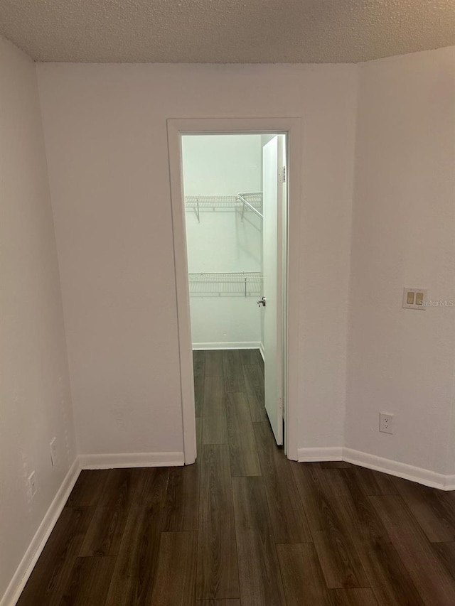 hall featuring dark hardwood / wood-style floors and a textured ceiling