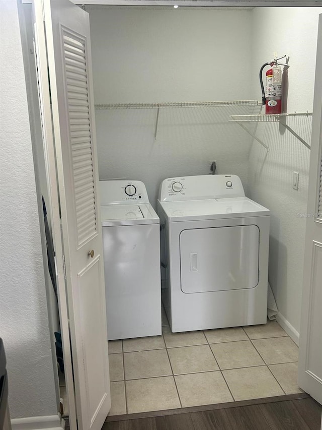 laundry area featuring washer and clothes dryer and light tile patterned floors