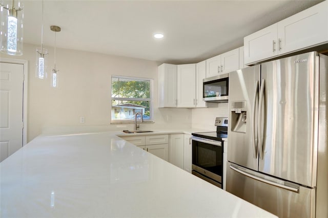 kitchen featuring sink, white cabinetry, decorative light fixtures, stainless steel appliances, and backsplash