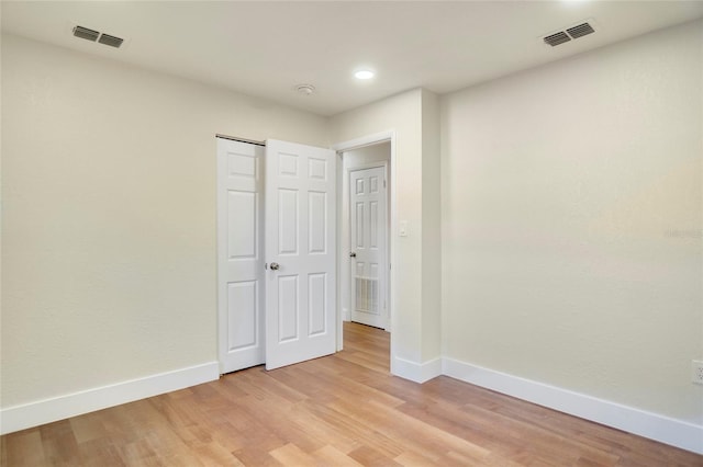 unfurnished bedroom with a closet and light wood-type flooring