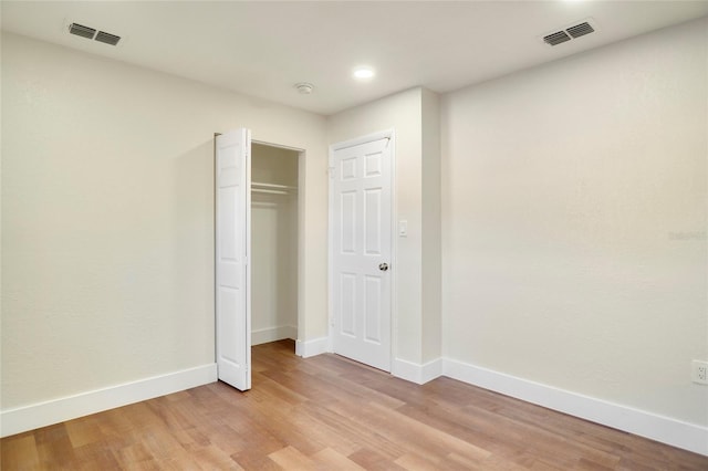 unfurnished bedroom with a closet and light wood-type flooring