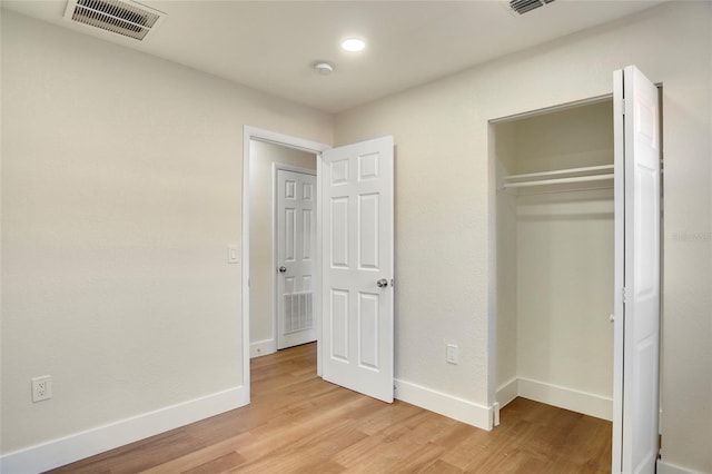 unfurnished bedroom featuring light hardwood / wood-style floors and a closet