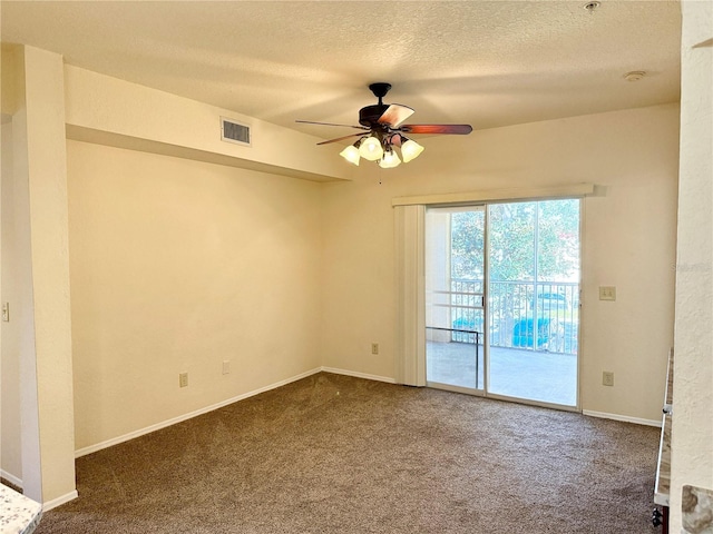 carpeted empty room with ceiling fan and a textured ceiling