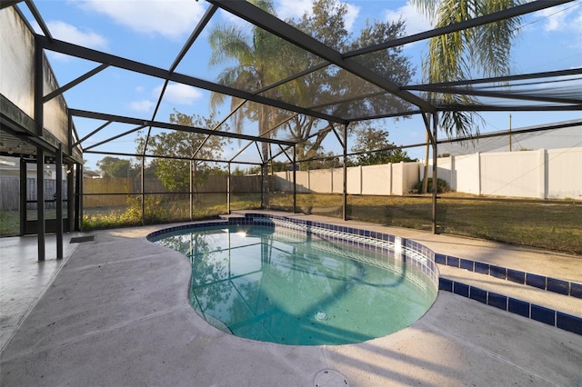 view of pool with glass enclosure and a patio area