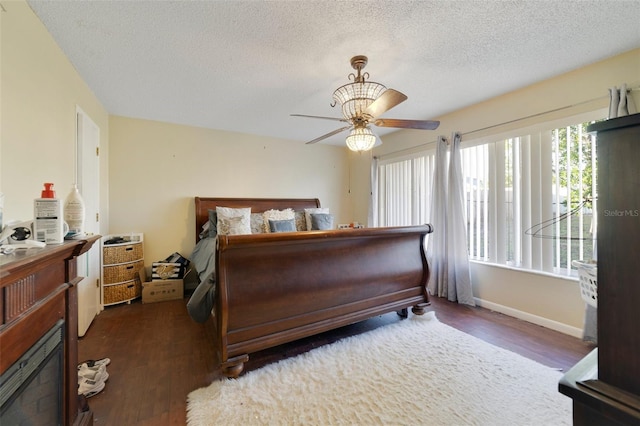 bedroom with ceiling fan, dark hardwood / wood-style flooring, and a textured ceiling