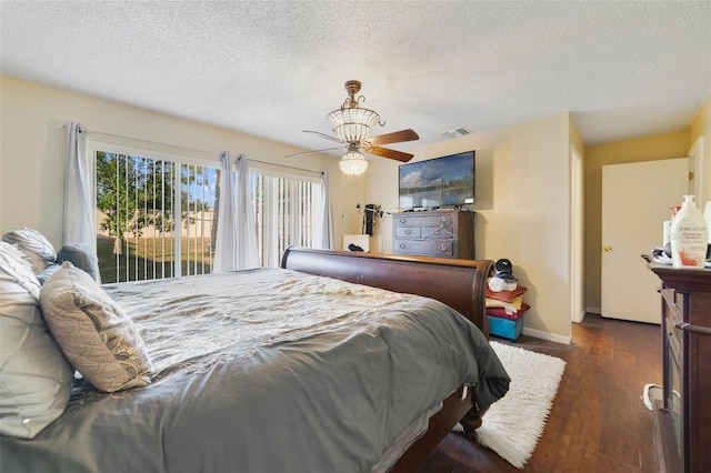 bedroom featuring dark wood-type flooring, access to outside, a textured ceiling, and ceiling fan