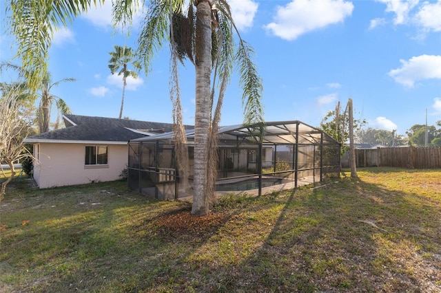 back of property featuring a yard and glass enclosure