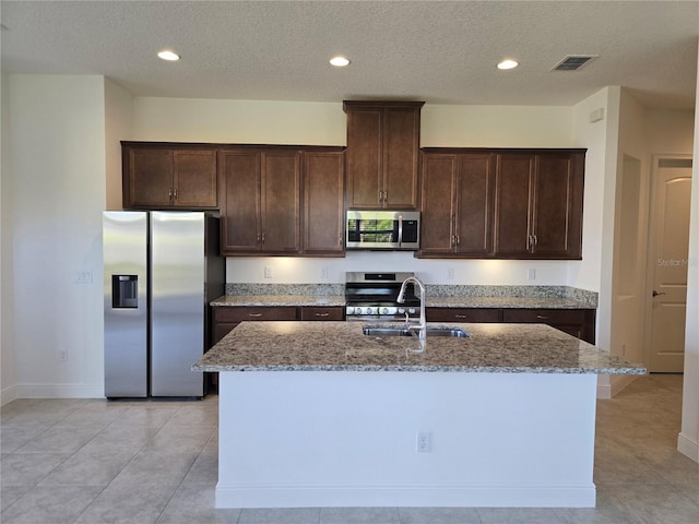 kitchen featuring light stone counters, appliances with stainless steel finishes, a sink, and visible vents