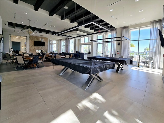 game room featuring a towering ceiling, pool table, and tile patterned floors