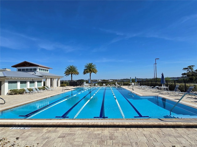 community pool with fence and a patio