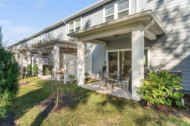 back of property featuring a patio area and a lawn