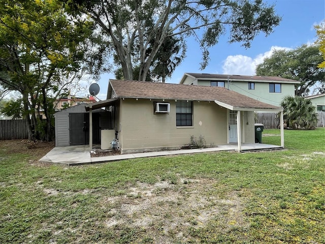 rear view of property featuring a storage shed, a lawn, and a patio area