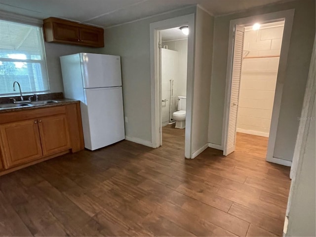 kitchen featuring sink, light hardwood / wood-style flooring, and white refrigerator