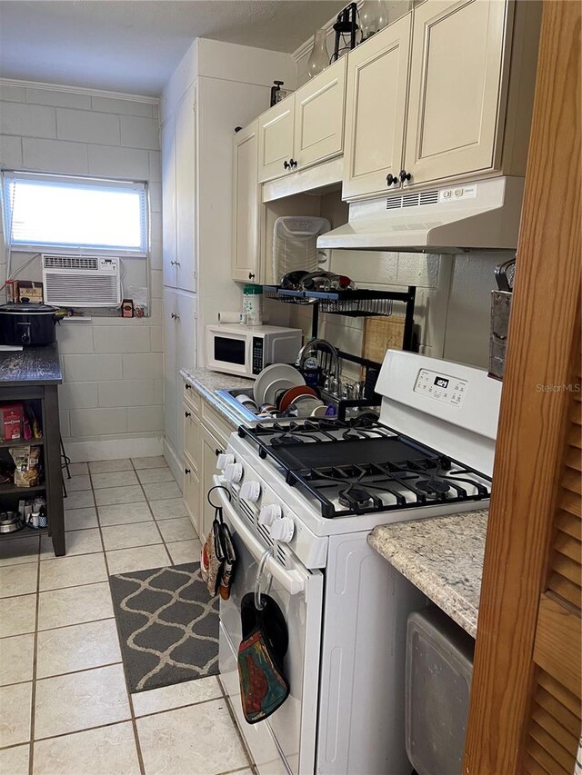 kitchen featuring light tile patterned flooring, white appliances, light stone countertops, and cooling unit