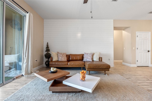 living room featuring ceiling fan and light hardwood / wood-style flooring