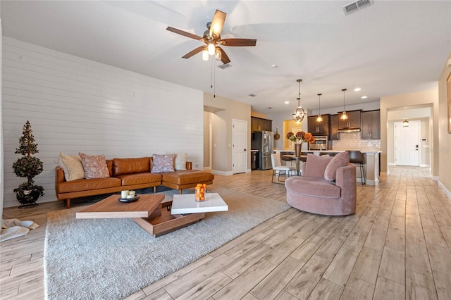 living room with ceiling fan and light hardwood / wood-style floors