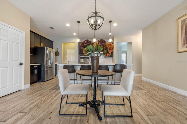 dining room with an inviting chandelier and light wood-type flooring