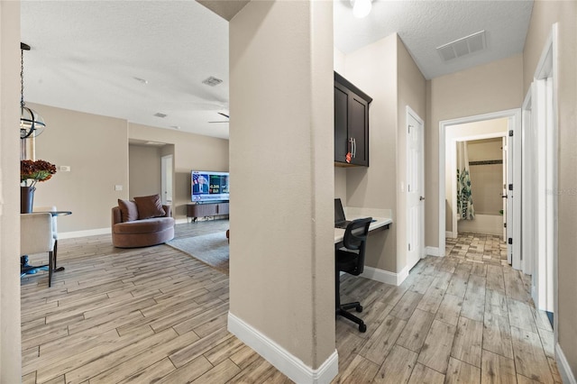 hall featuring a textured ceiling