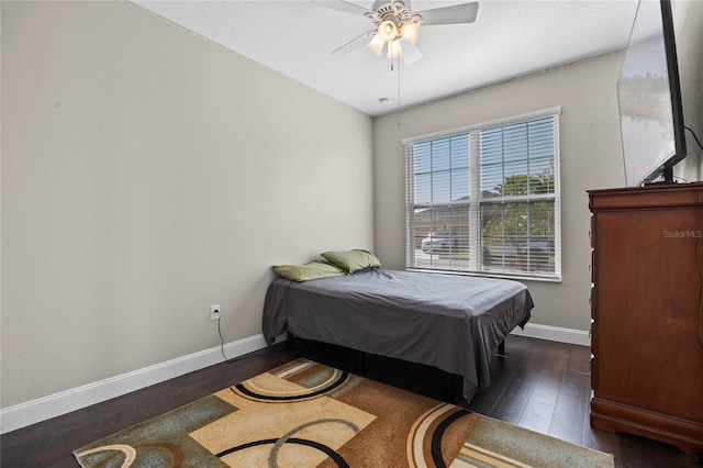 bedroom with dark hardwood / wood-style floors and ceiling fan