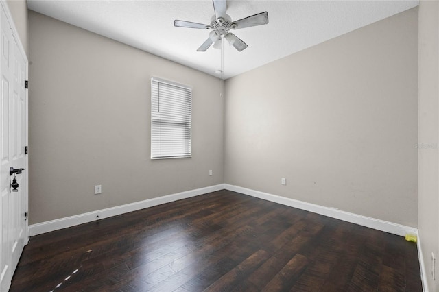 empty room featuring dark wood-type flooring and ceiling fan