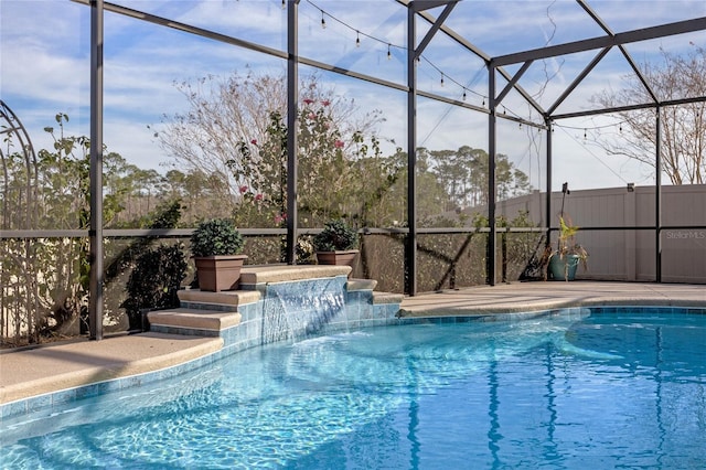 view of pool with pool water feature and glass enclosure