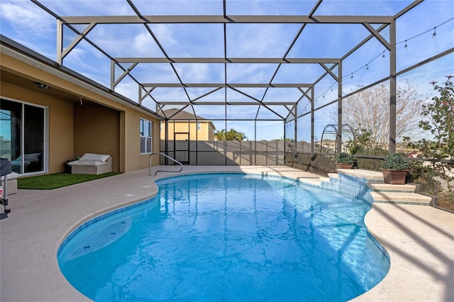 view of pool featuring glass enclosure and a patio area