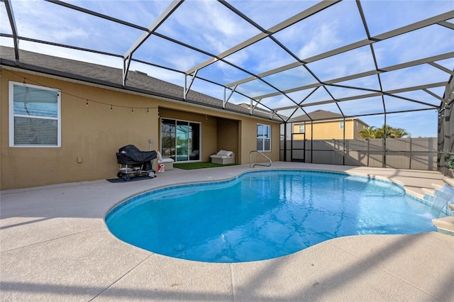 view of pool with pool water feature, glass enclosure, and a patio area