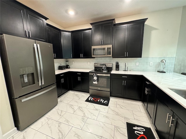 kitchen with appliances with stainless steel finishes and backsplash