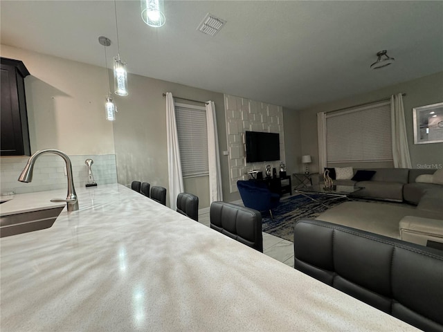 kitchen featuring pendant lighting, sink, and decorative backsplash