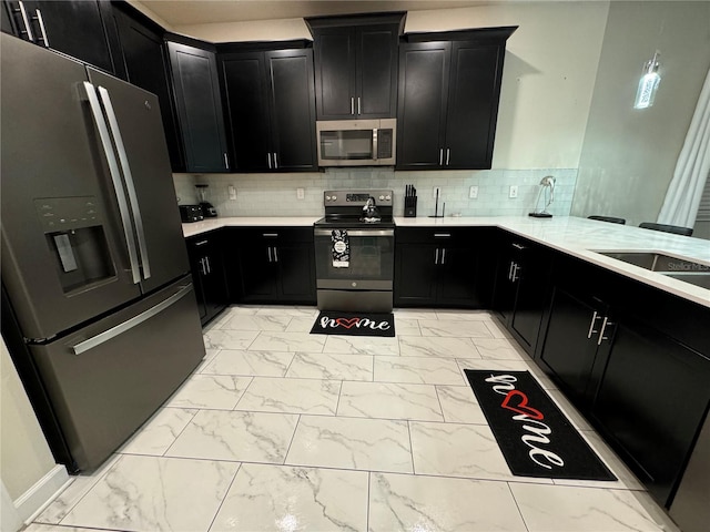 kitchen featuring stainless steel appliances, kitchen peninsula, sink, and decorative backsplash