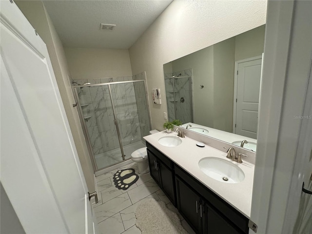 bathroom with vanity, an enclosed shower, a textured ceiling, and toilet