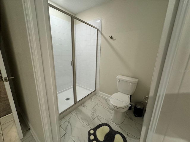 bathroom featuring toilet and a shower with door