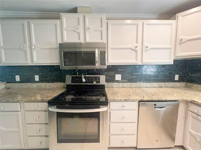 kitchen with decorative backsplash, light stone countertops, white cabinets, and appliances with stainless steel finishes