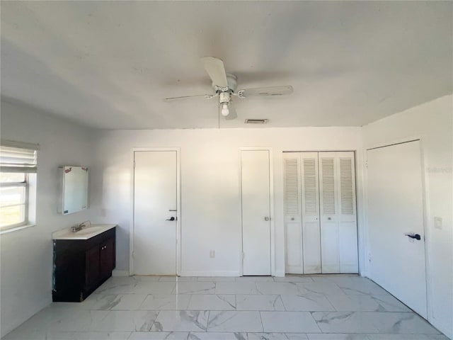 unfurnished bedroom with sink and ceiling fan