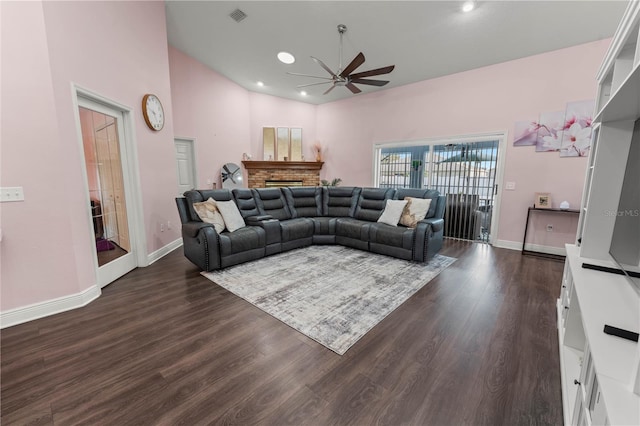 living room with dark hardwood / wood-style flooring, a fireplace, high vaulted ceiling, and ceiling fan