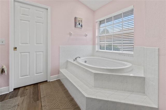 bathroom featuring hardwood / wood-style floors and tiled bath