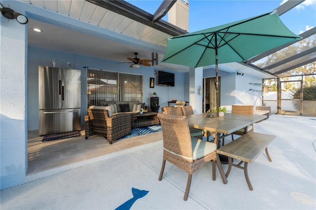 view of patio featuring an outdoor hangout area, ceiling fan, and glass enclosure