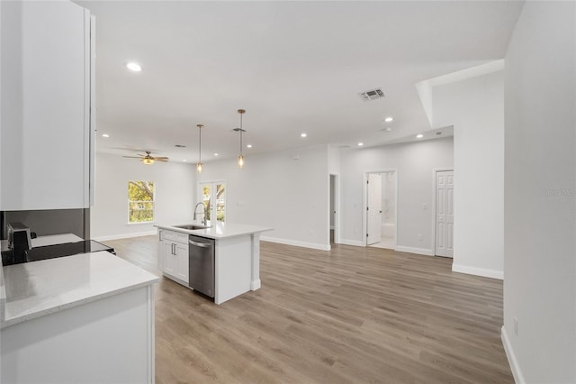 kitchen featuring pendant lighting, sink, white cabinetry, an island with sink, and stainless steel dishwasher